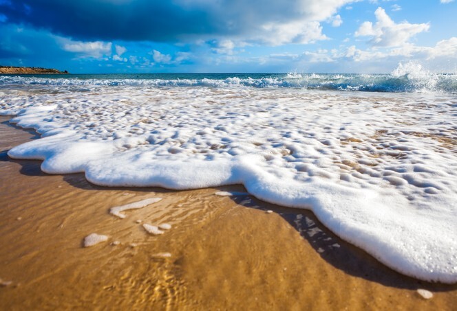 Waves wash over golden sand